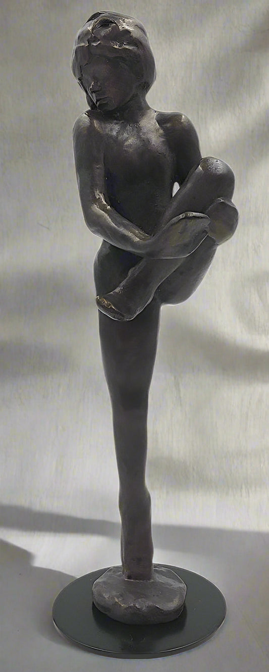 Bronze sculpture of a standing figure with arms crossed on a black base