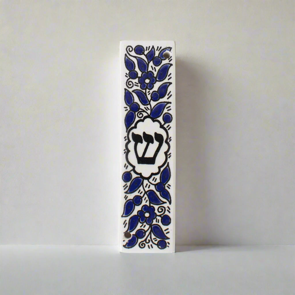 Decorative mezzuzah case with blue floral patterns on a white background