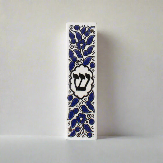 Decorative mezzuzah case with blue floral patterns on a white background